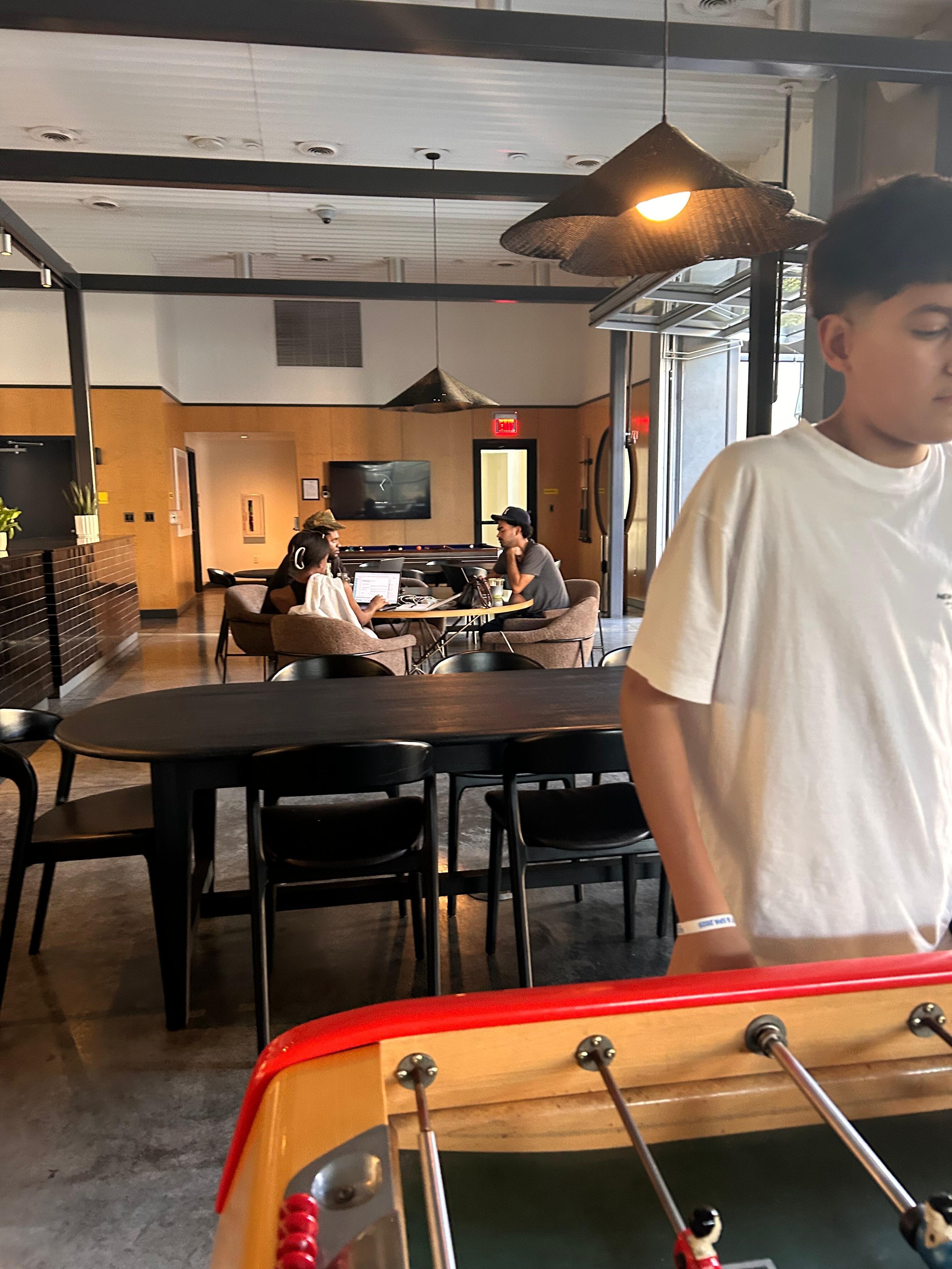 Clubhouse foosball and a few folks enjoying remote work. 