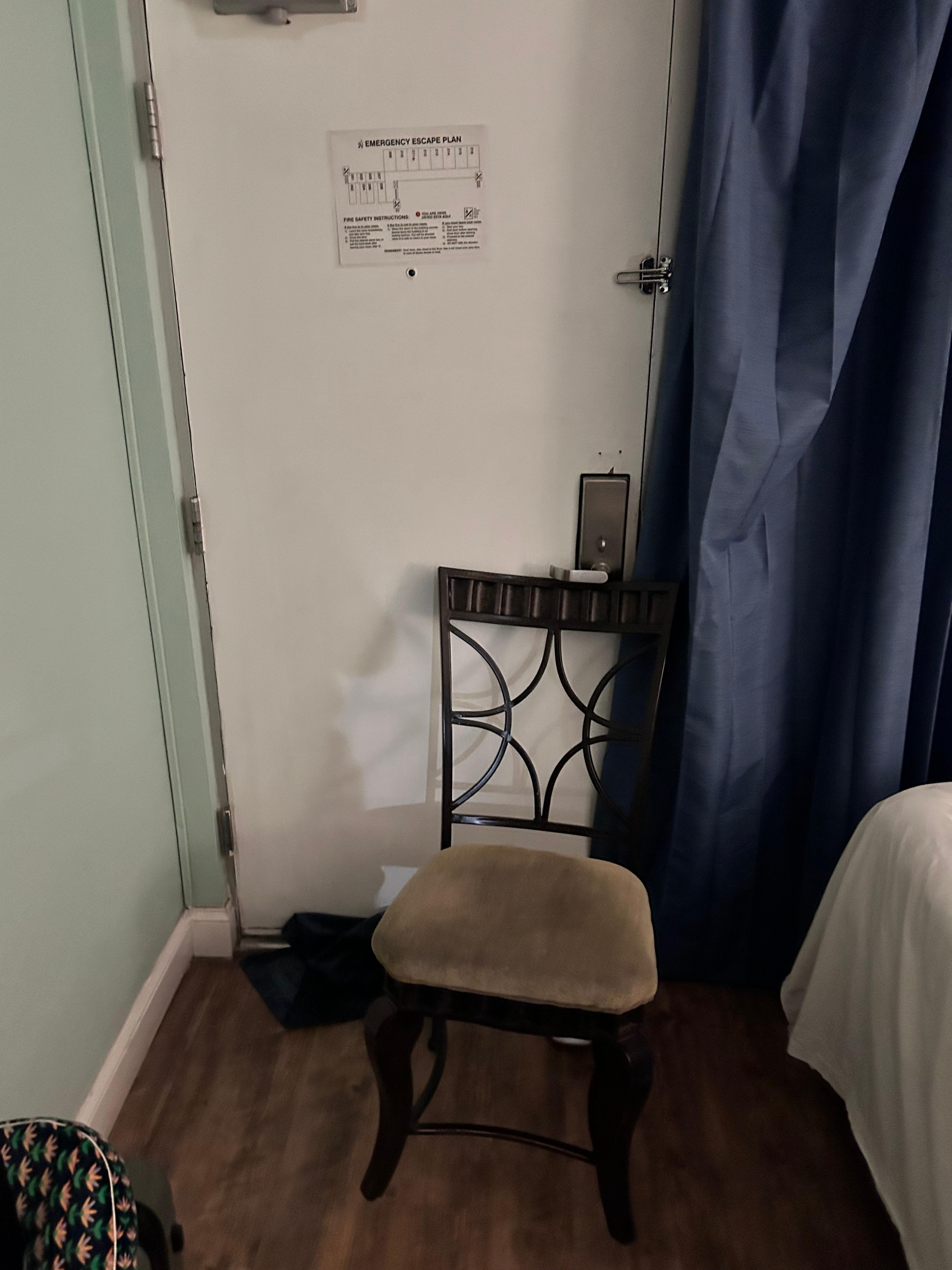 Blocking light and sound below door and chair because people were running by the door speaking loudly all night