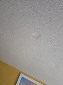 Hole in ceiling above one of the beds