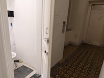The door of the shared toilet the opens to the complete floor.