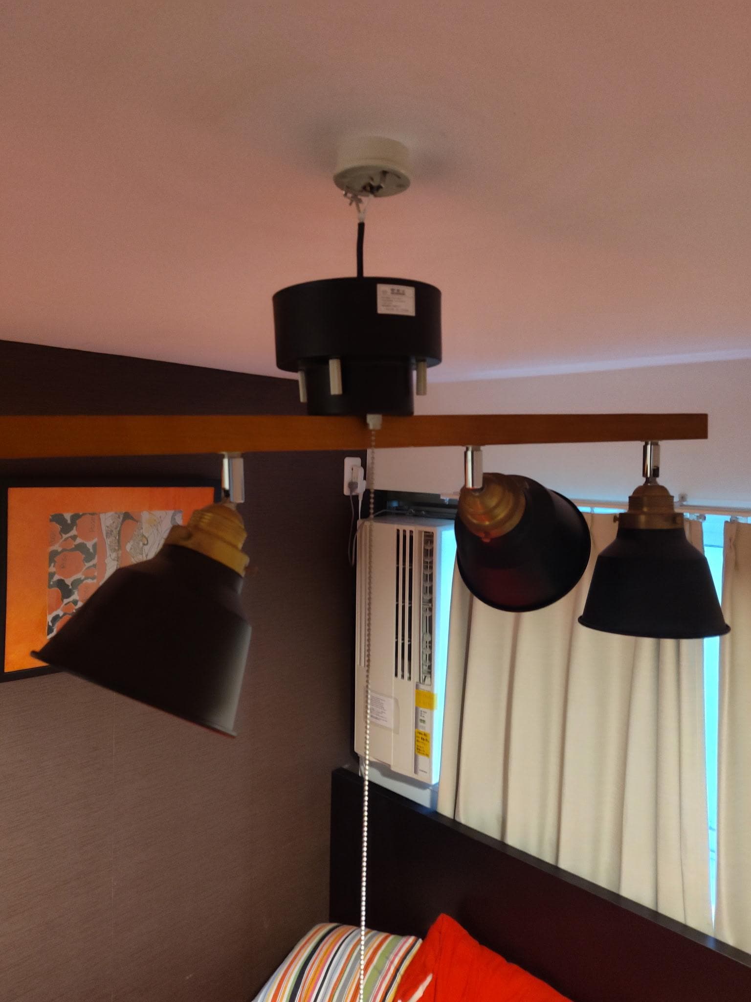 Broken and hazardous light fixture, directly above bed