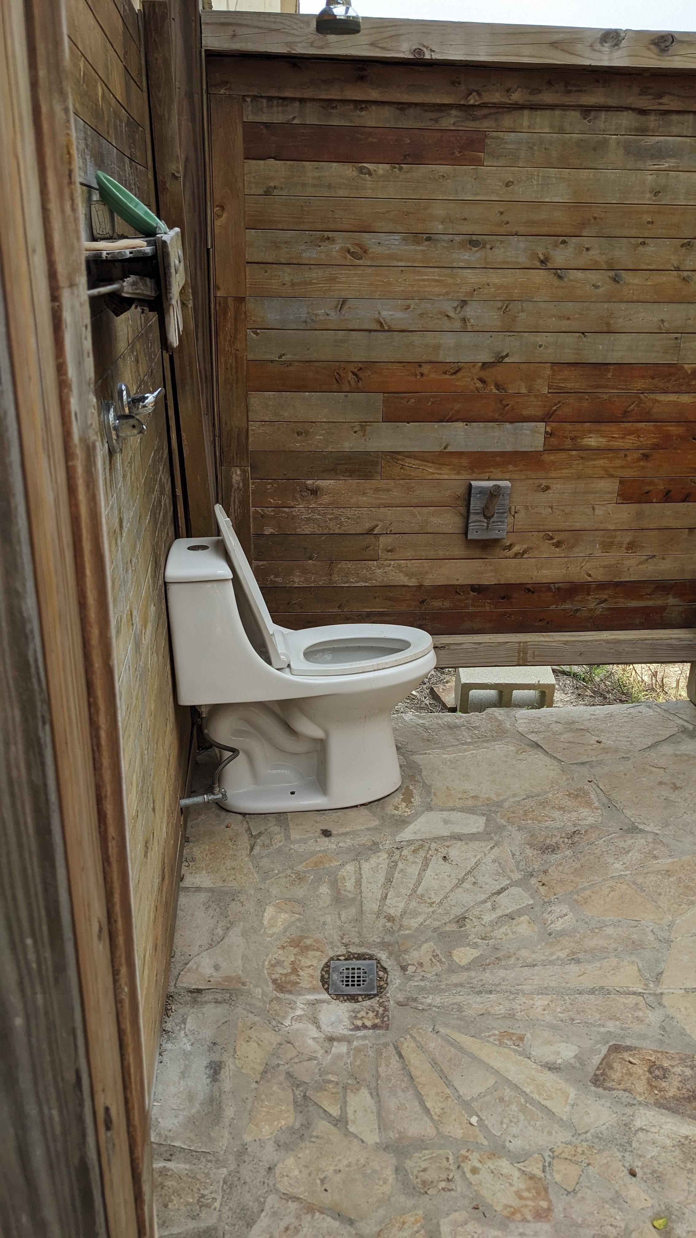 Outside "bathroom" with showerhead coming out of the wall (not in picture.)
