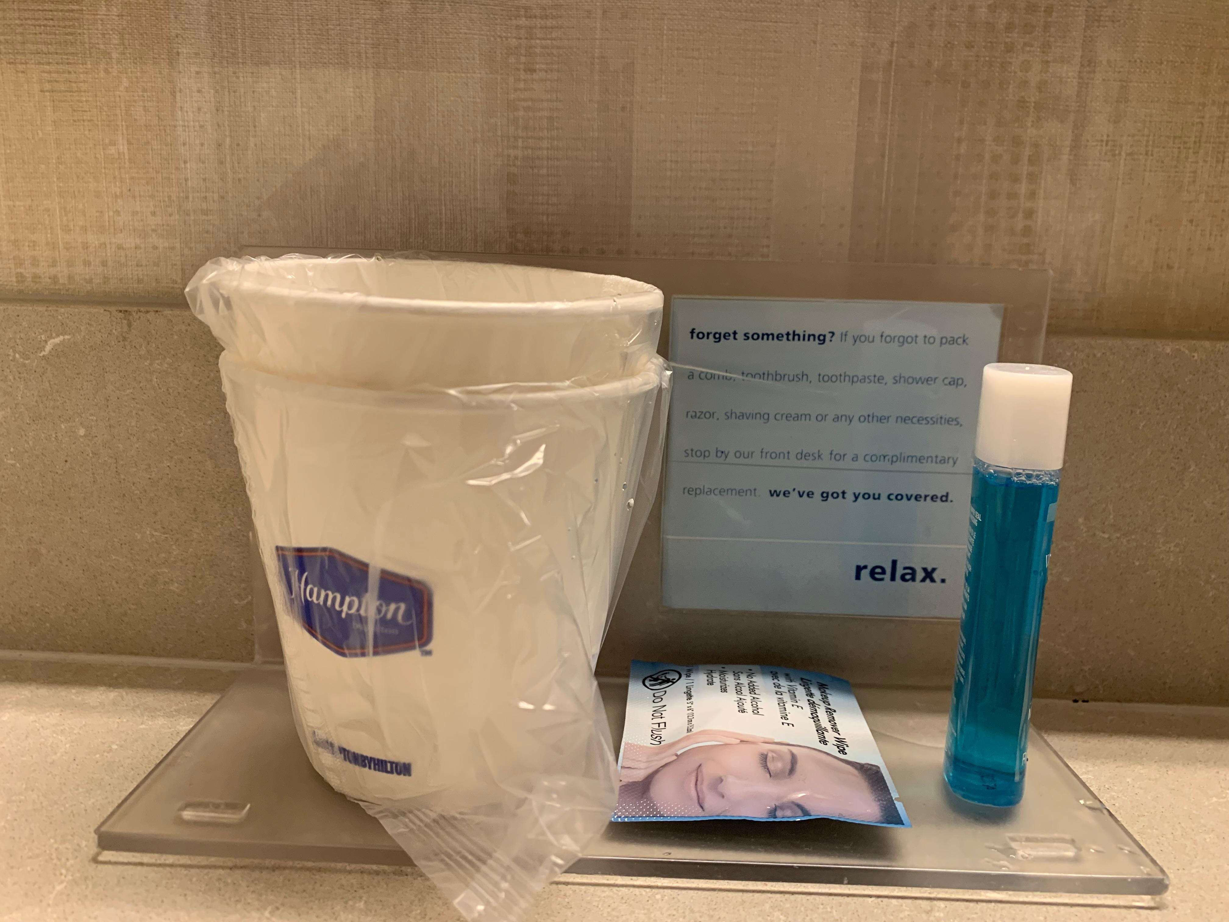 Toiletries offered to guests behind the front desk listed on the plaque. 