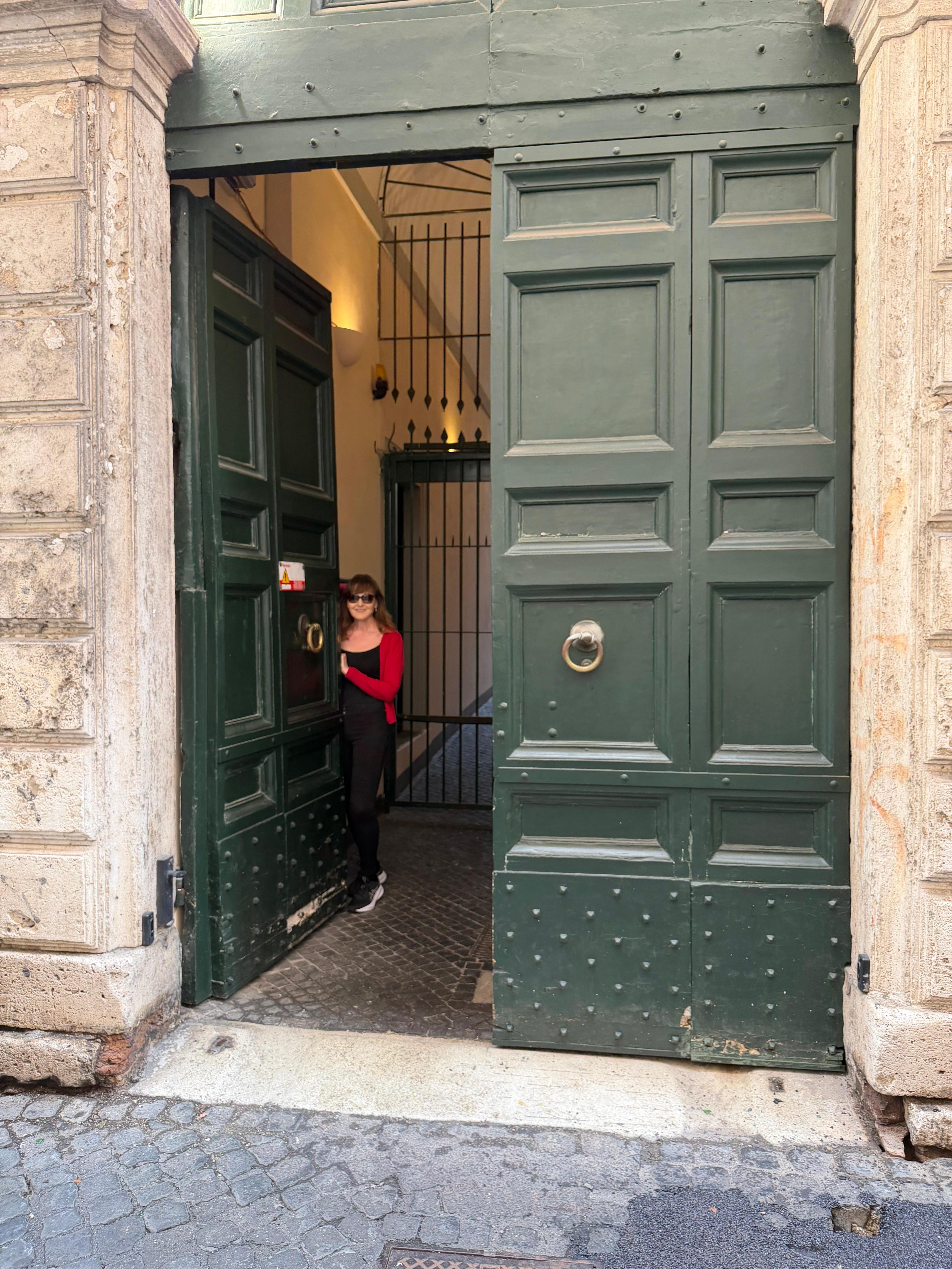 Gigantic door at 6 Via dell’Arco de Ginnasi - very narrow street off Corso Vittorio Emanuele II - see green pharmacy sign that’s lit up - other end of narrow street is a Tigre supermarket 
