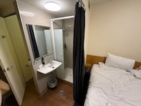 Tiny bathroom not separated from bed area