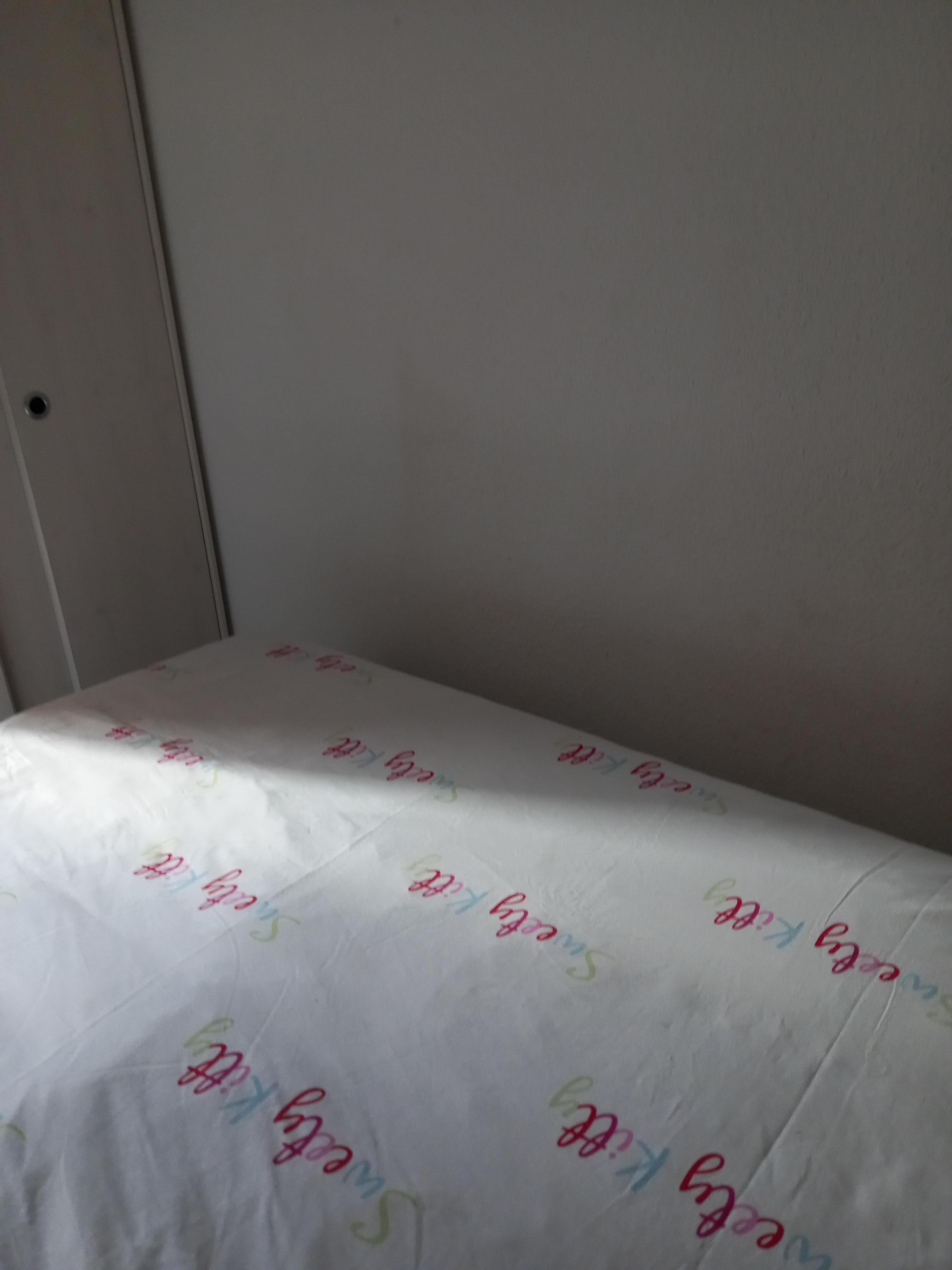 Passage entre le pied du lit et le mur