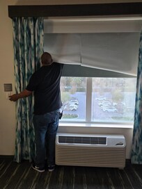 The maintenance guy trying to fix the blinds