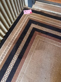 Pee stained carpet at front door next to 'Take your shoes off' hand printed sign!