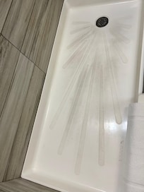 Floor of shower appears to be soiled or stained.