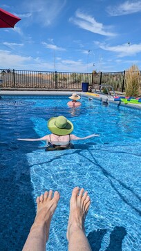 How we spend much of our time...Just floating around in the pool. My girls - and my feet - to prove I was there too! Look at that sky!