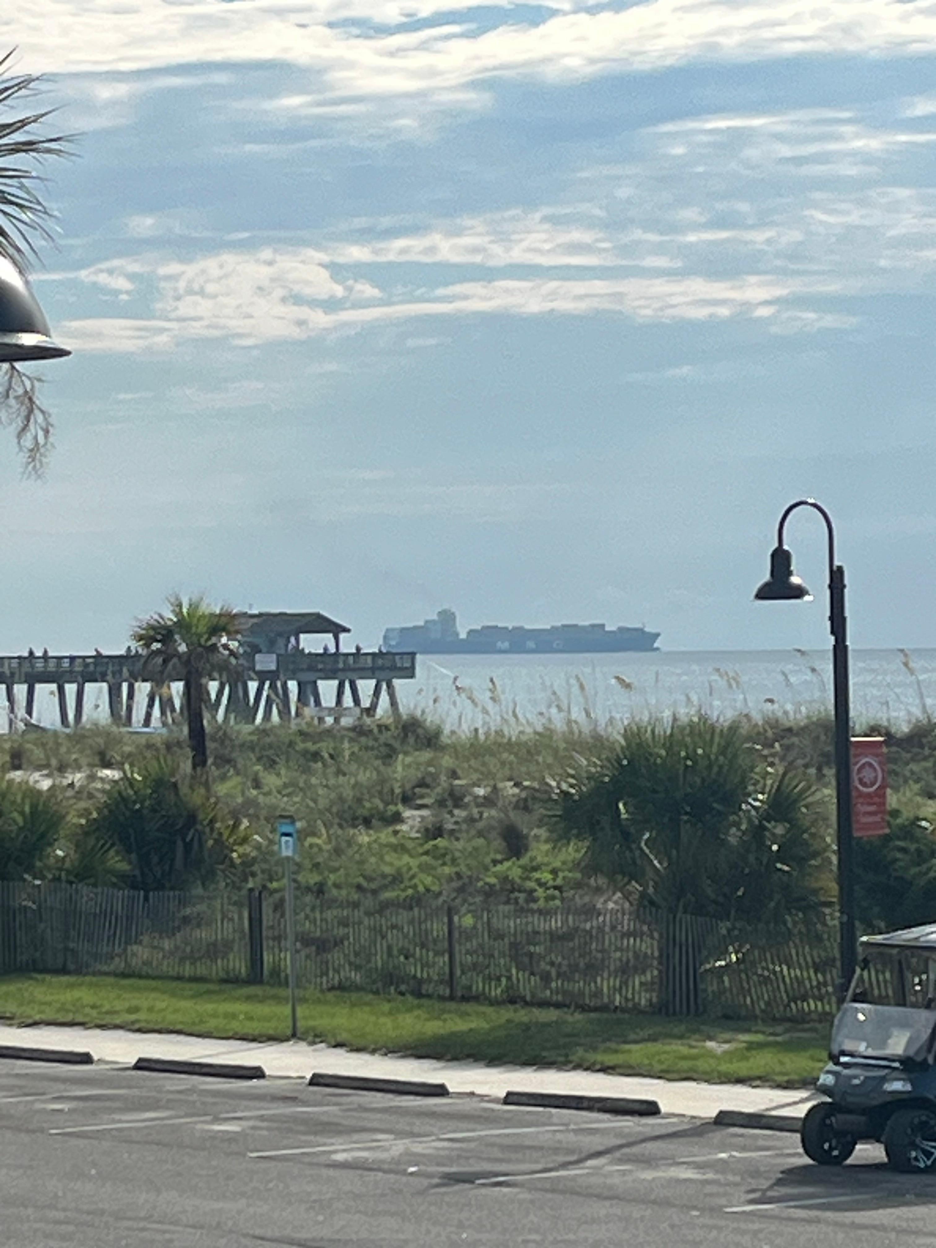 View of pier with cargo ship in back ground 