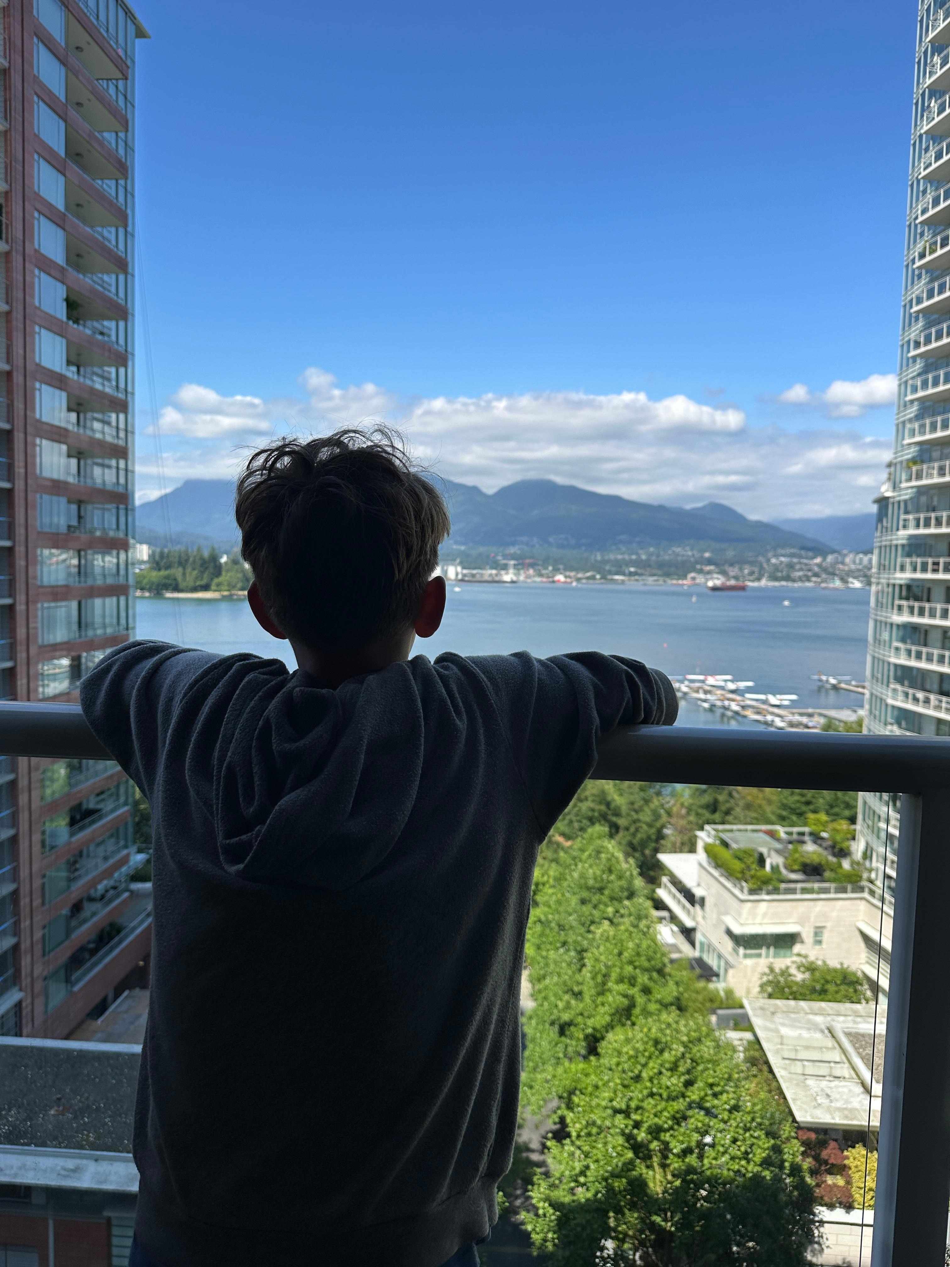 Grandson admiring the view of Coal Harbor from our Pinnacle Hotel Harbourfront balcony