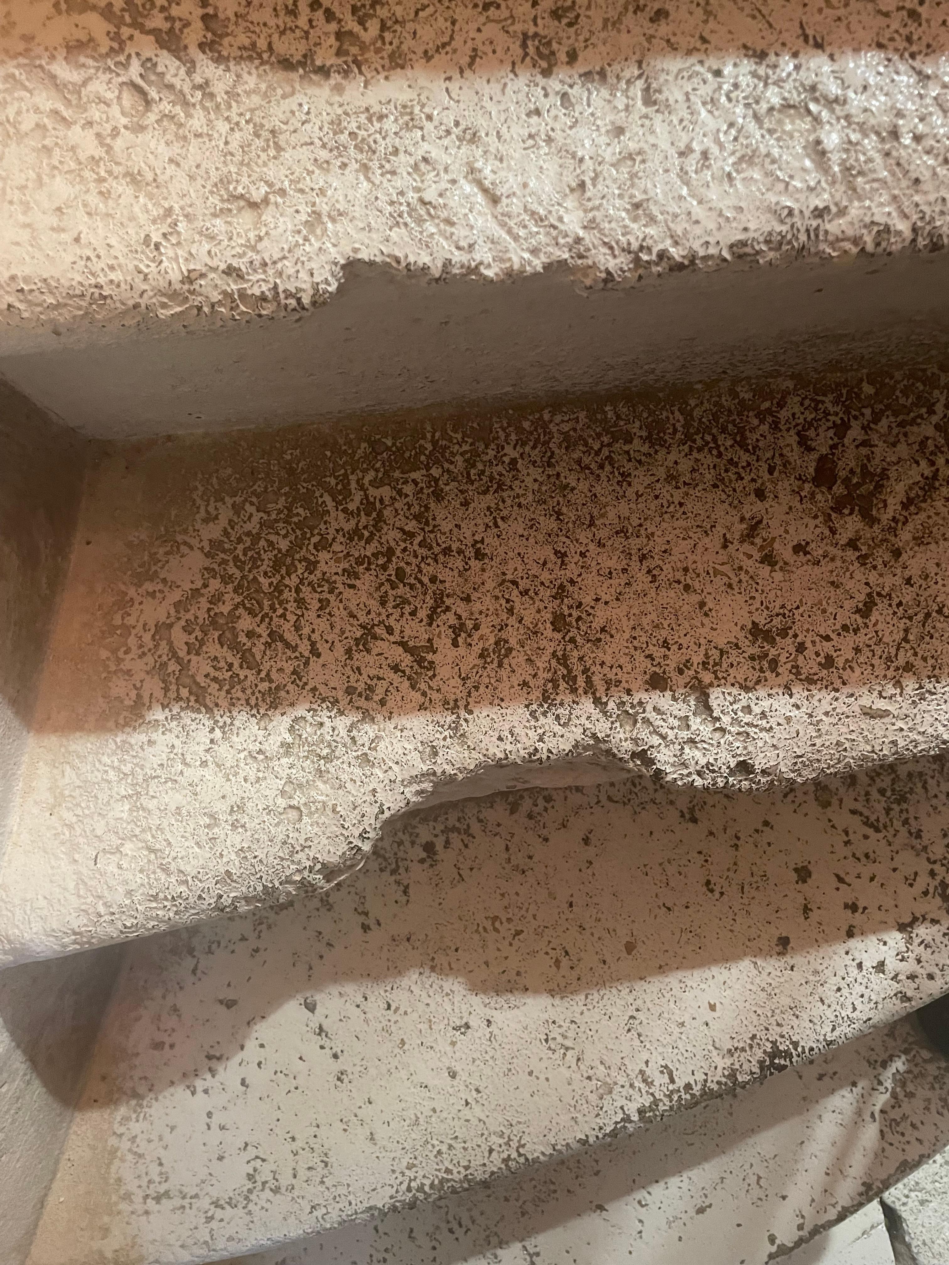 One of numerous broken stone steps on staircase.  