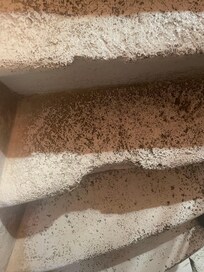 One of numerous broken stone steps on staircase.