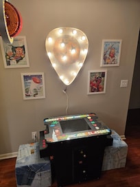 Guitar pick light over multicade game.