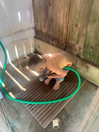 Rinse off the sand or use the brush attached to the bench outside