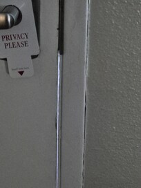 Unsafe front door with light coming through door frame