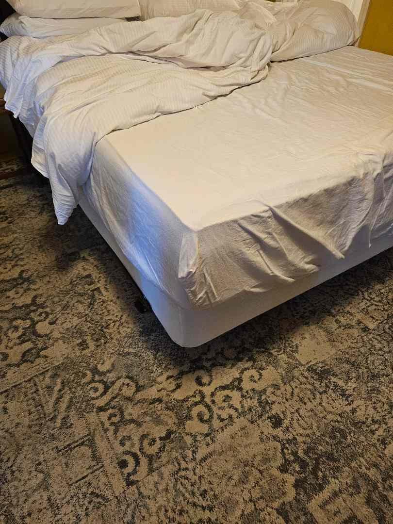 bed with duvet and mattress cover, no sheets