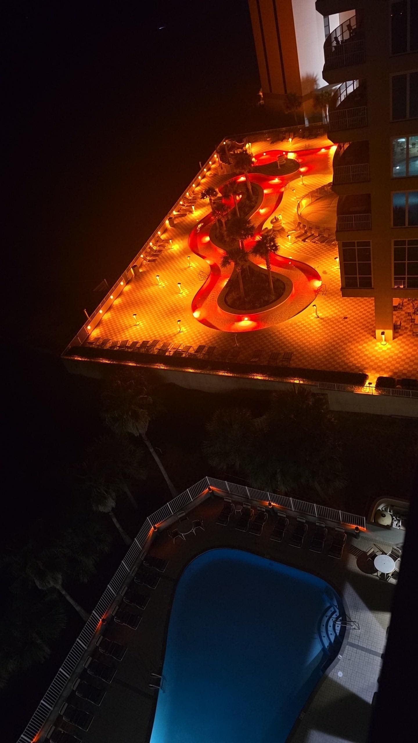 Night view of the unit's pool and the neighbors lazy river pool. 