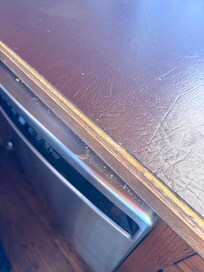 Dirt on top of the dishwasher.