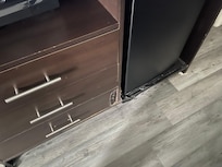 Broken tv stand, they used a door stopper on the left and some kind of food container on the right. Tape to cover or maybe help secure the from damage.