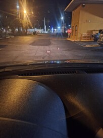 Kids shoes left in middle of parking lot exit.