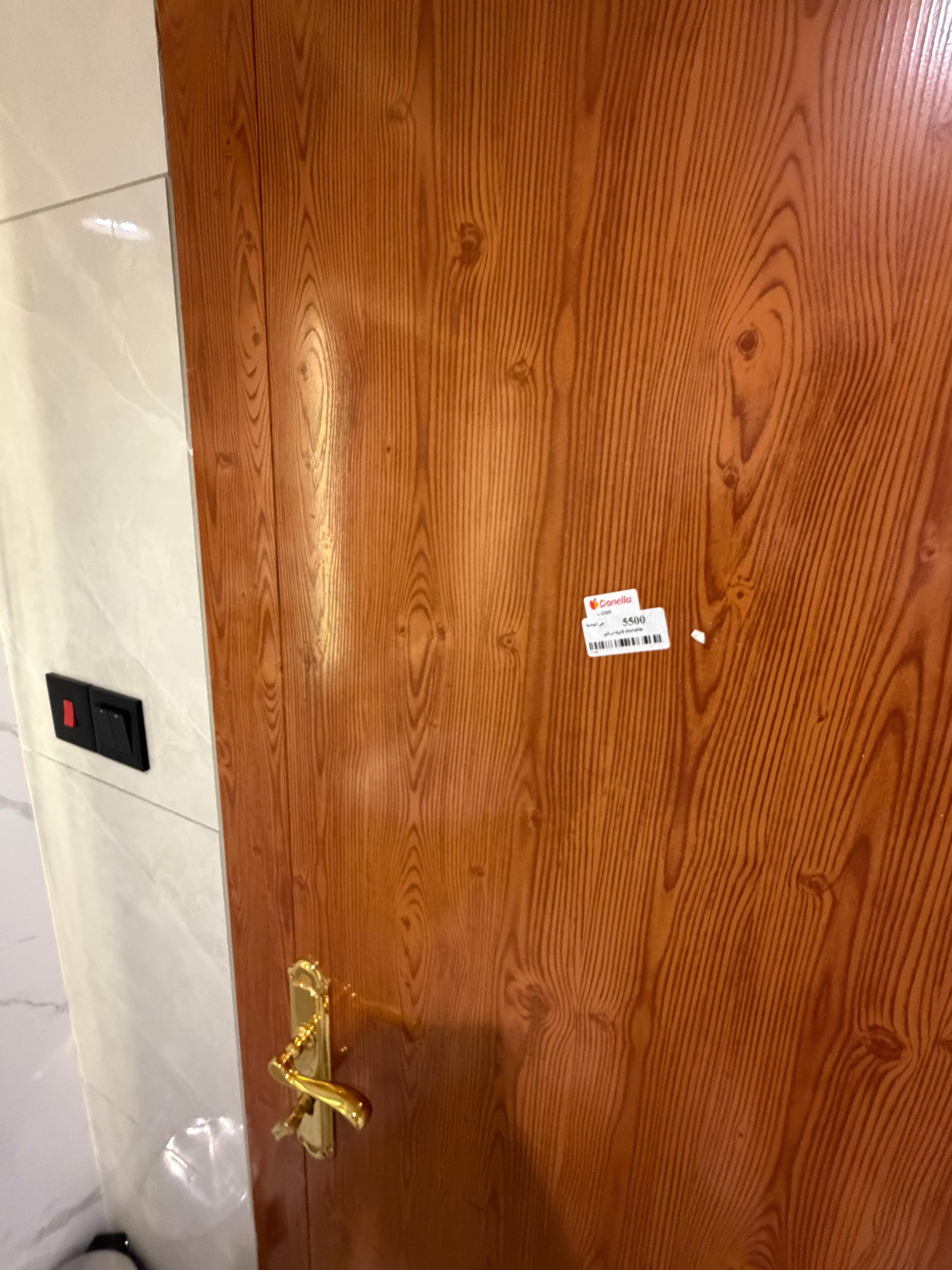 Bathroom door has  a women clothing sticker on it 