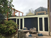 Outdoor view of a lower floor room with covered outdoor area above.