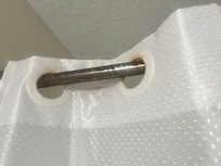 Shower rod & curtain in bathroom near room with 3 double beds