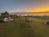 Families and couples picnicking and watching the sun go down