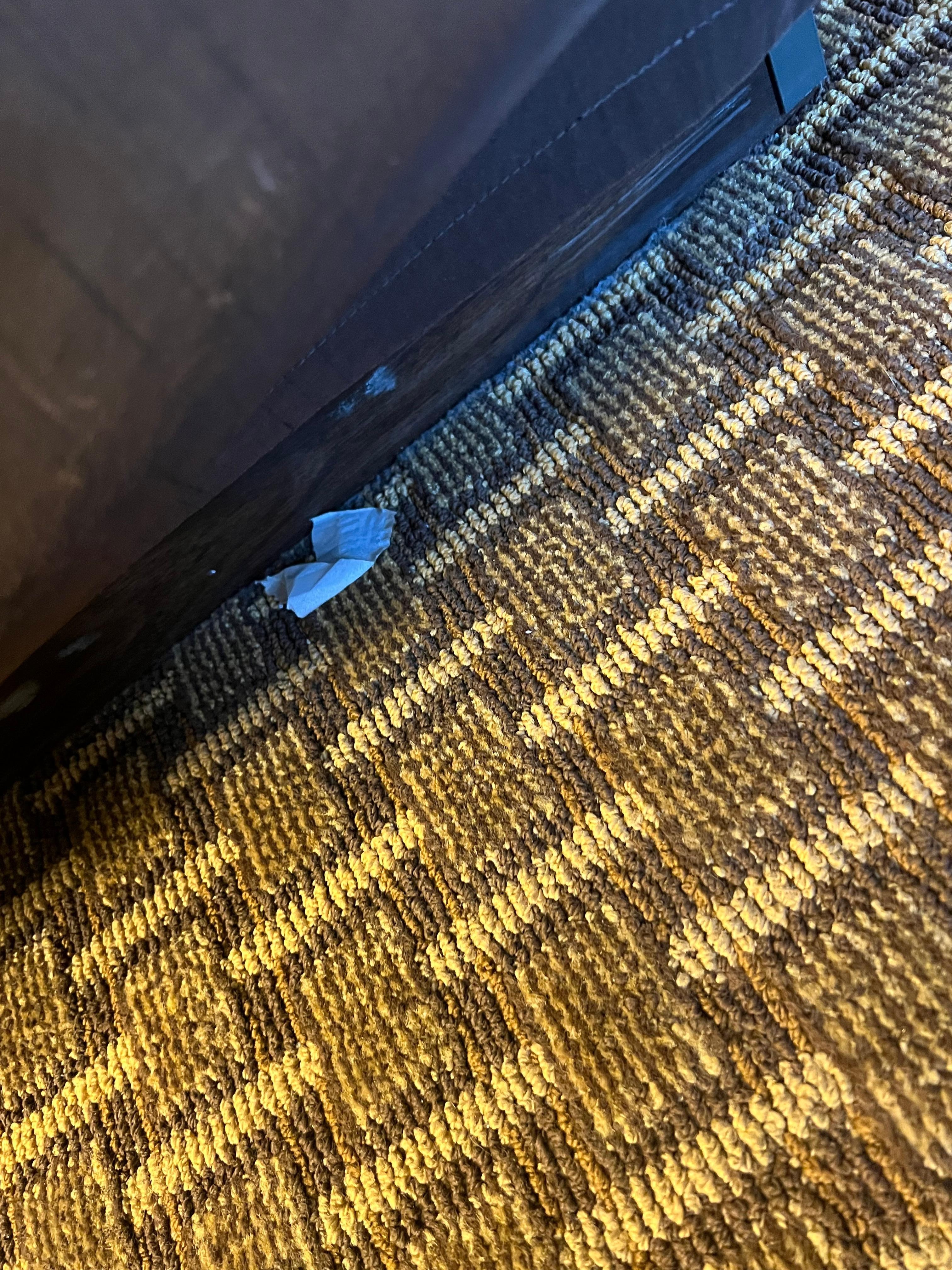 A piece of toilet paper or tissue laying next to the bed