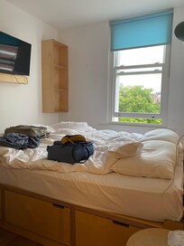 Seng og vindu med utsikt ut til gata.