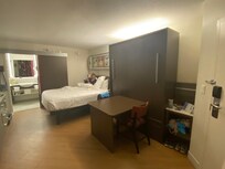 Quarto com uma das camas fechadas, virando uma mesinha