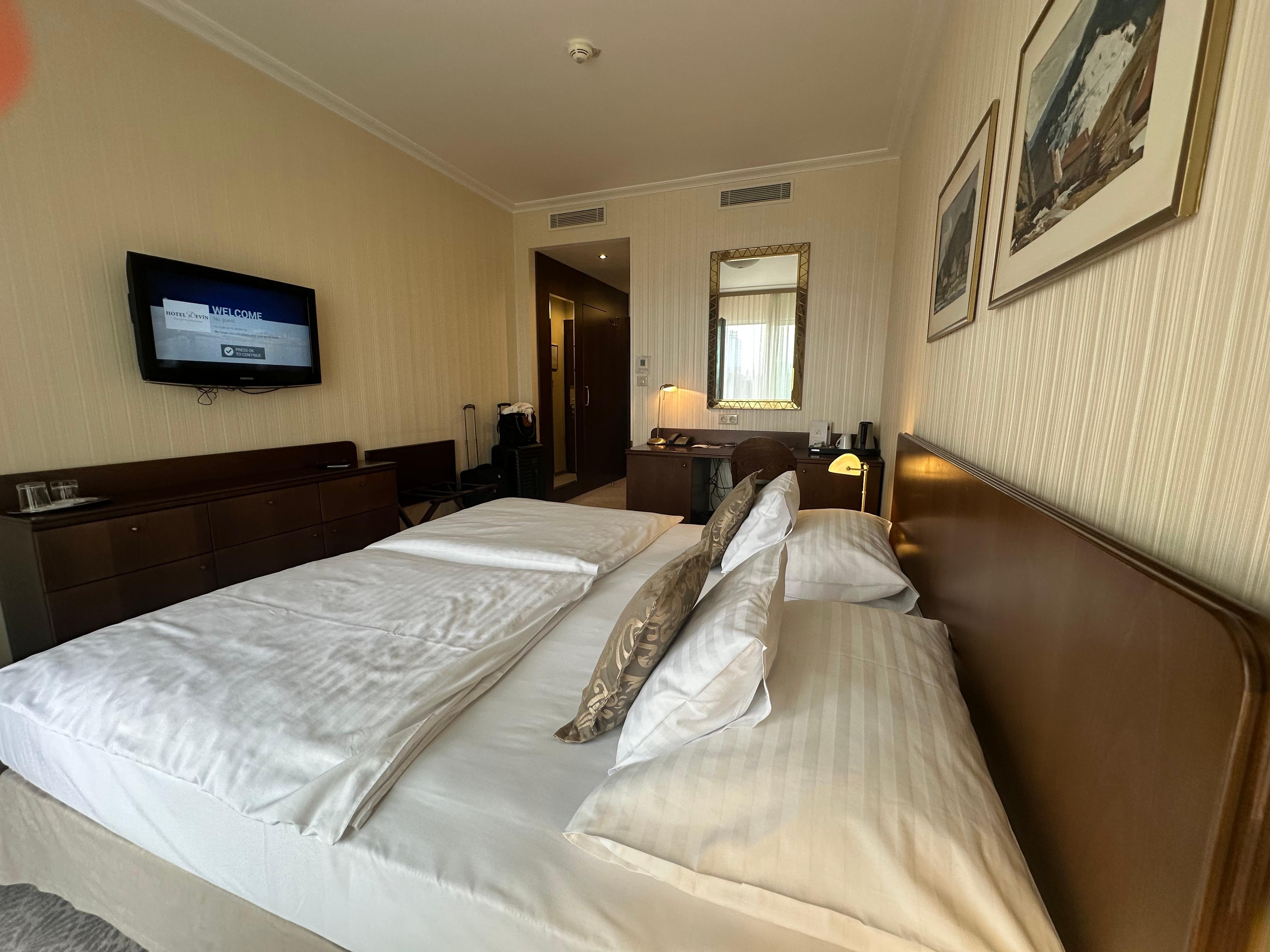 Twin beds with twin comforters pushed together to make one king bed. Is standard in EU. Ask for extra pillows to bridge the gap. 