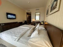 Twin beds with twin comforters pushed together to make one king bed. Is standard in EU. Ask for extra pillows to bridge the gap.