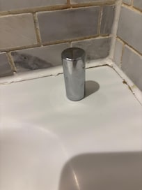 The piece of flying metal and the dirty grout.