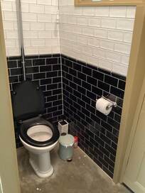 Toilet with no door, located next to the kitchen.