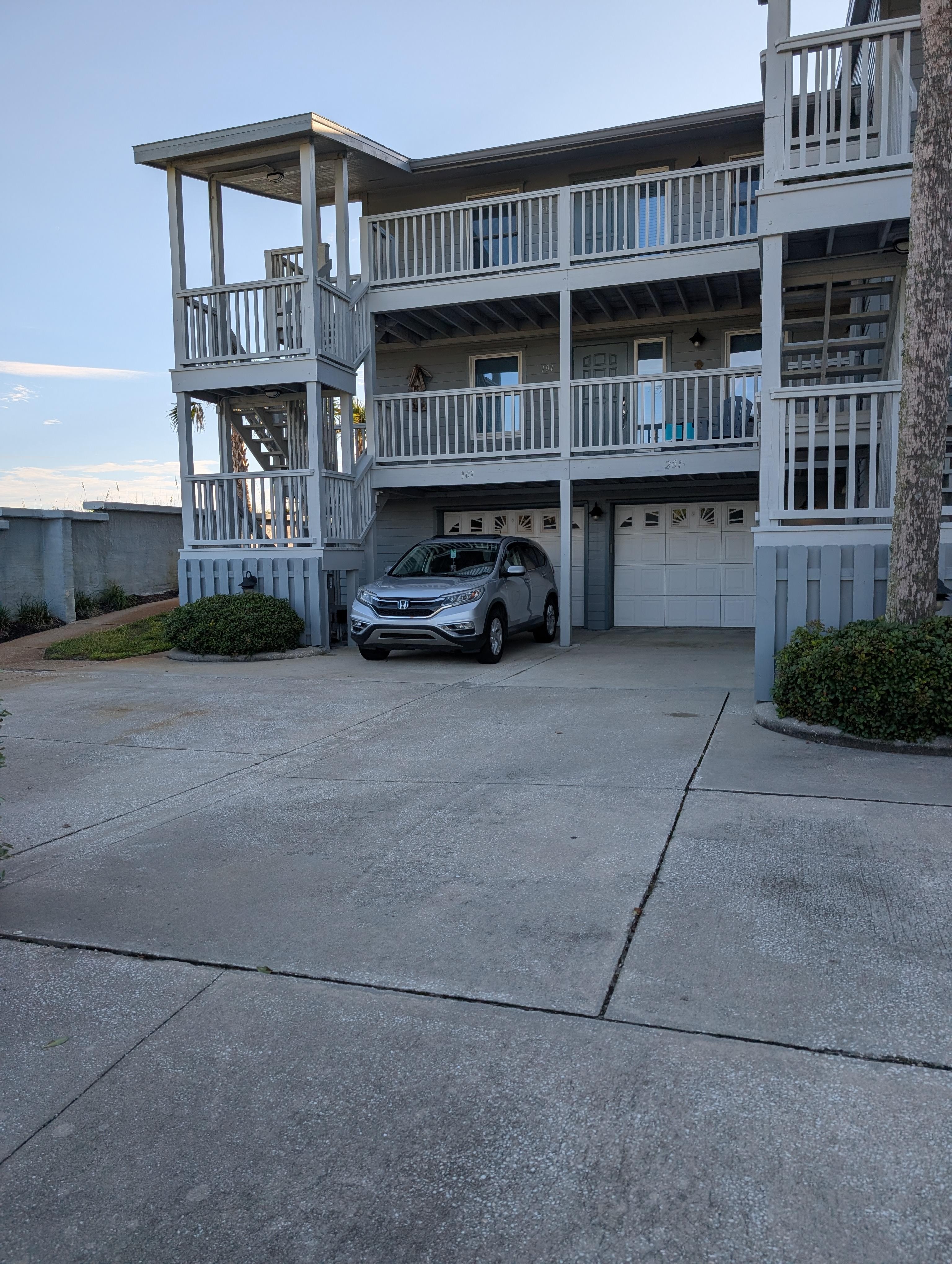 The unit is just above the car but you can walk around the left of the building and use the backdoor instead of the stairs. 