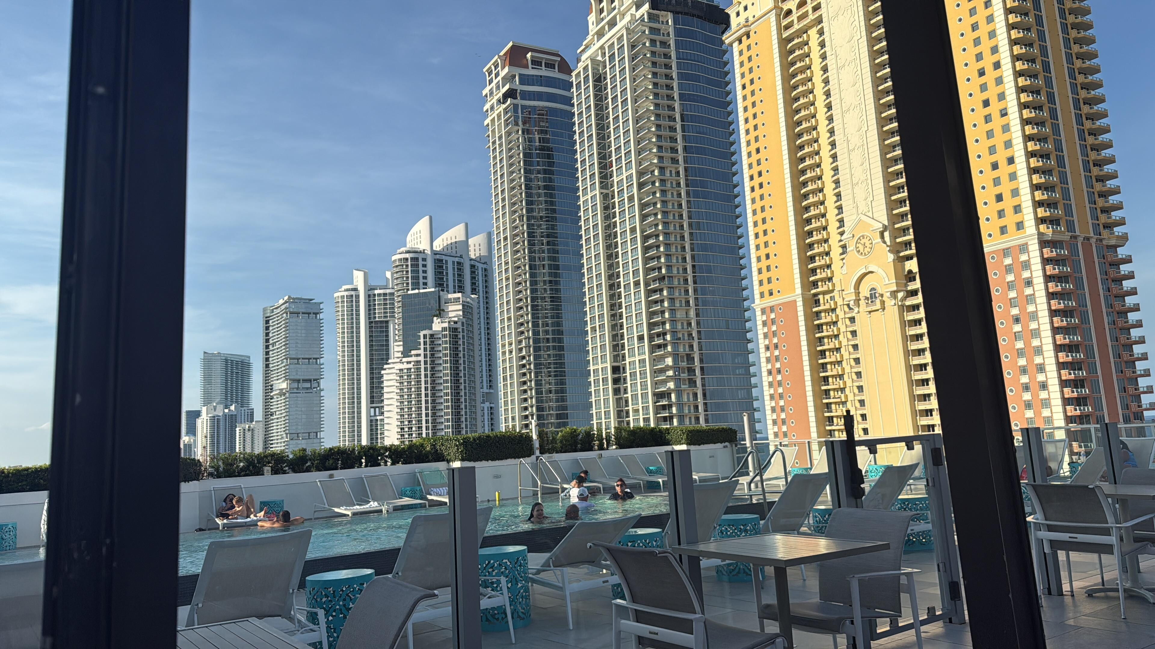 Cadeiras e tendas ao lado da piscina no rooftop 