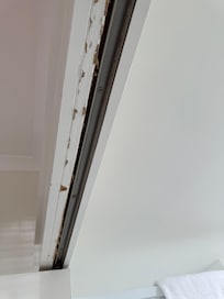 The state of the door frame between the bedroom and the bathroom. I am only allowed 8 photos. I have about 25-26. Chipped furniture, rusted lamps, broken sliding dividers.