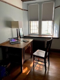 Welcoming room with Arts and Crafts style furnishings, leaded windows which open, and quiet, green outlook.