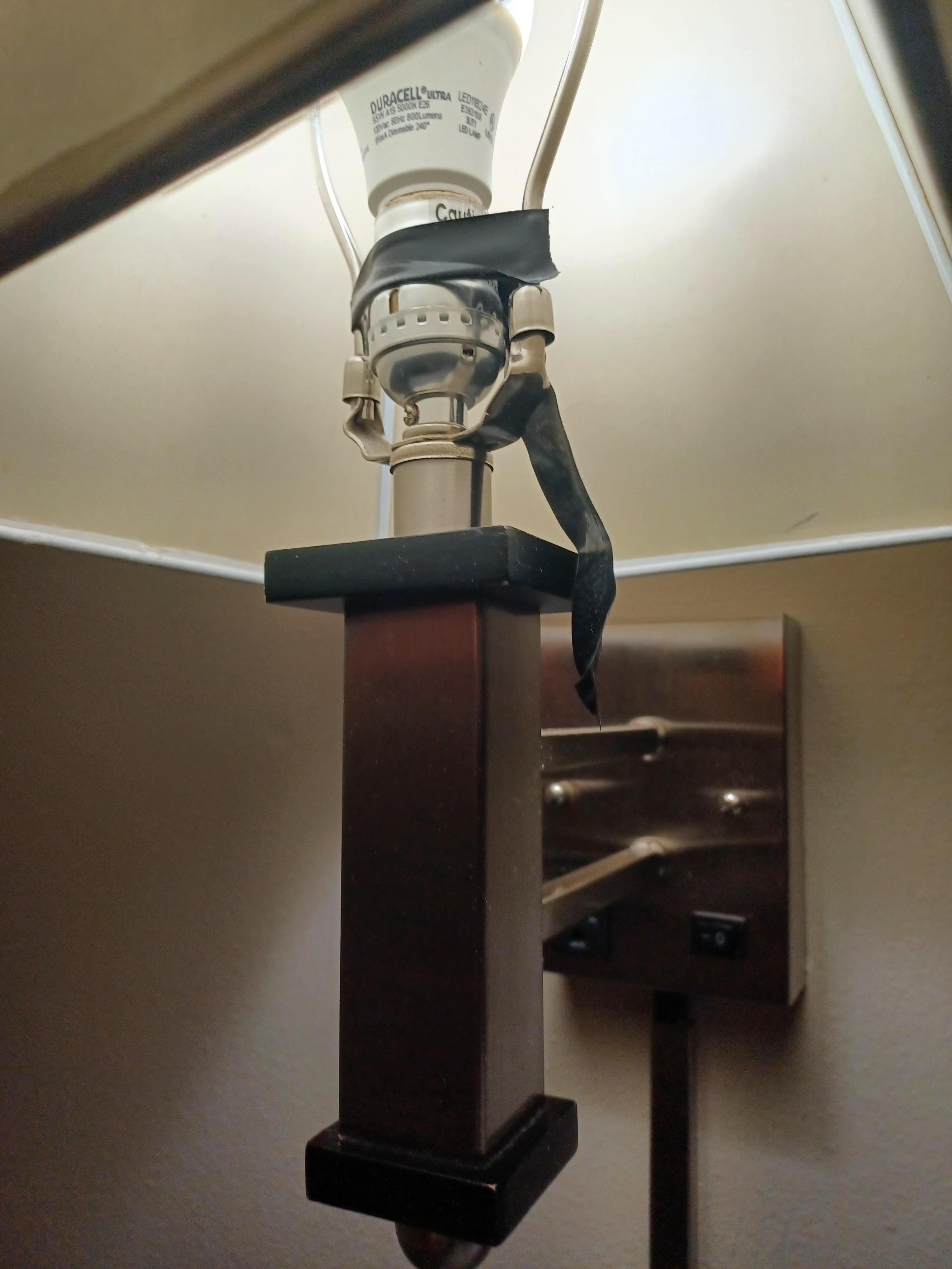 Electric tape on bed side lamp both sides