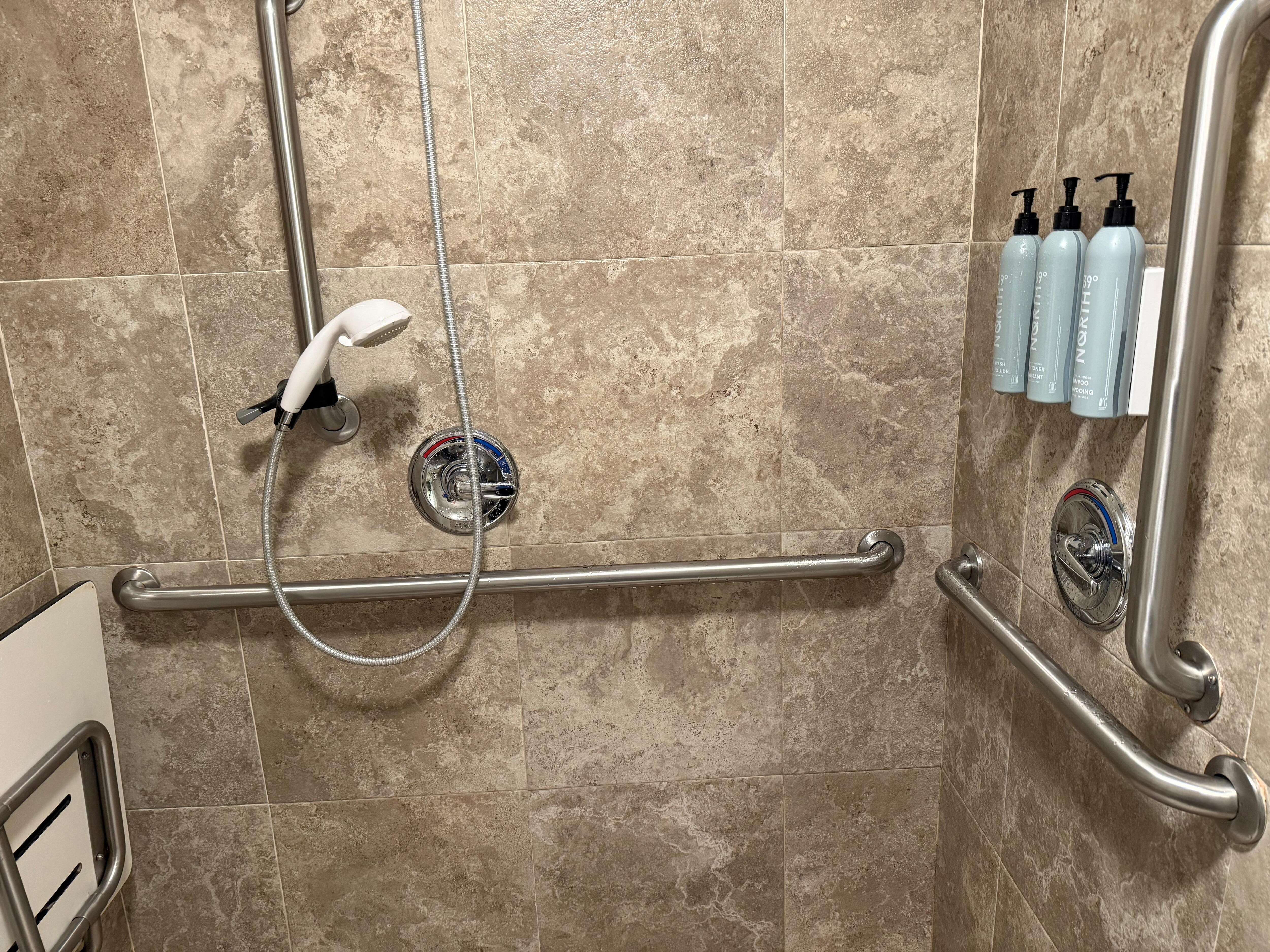 Toiletries on opposite wall from seat for disabled person