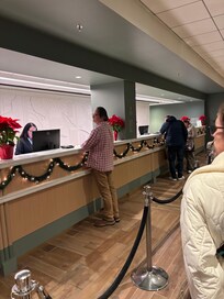 Two workers, one being trained at front desk.