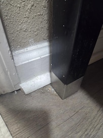 Dirt in the corners of the floor and trim.