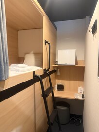 The cabin, a tiny fridge and a small table and stool.