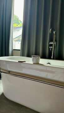 Our room with a bathtub next to a bed.