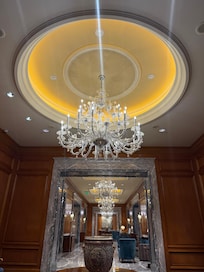 Main hallway with lots of marble and chandeliers.