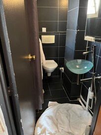 Tiny bathroom, note the sink and angle of the faucet.