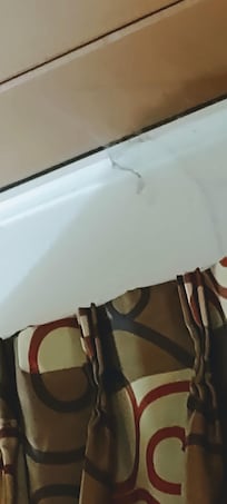 Can't see it well but cob web gets from ceiling to curtain